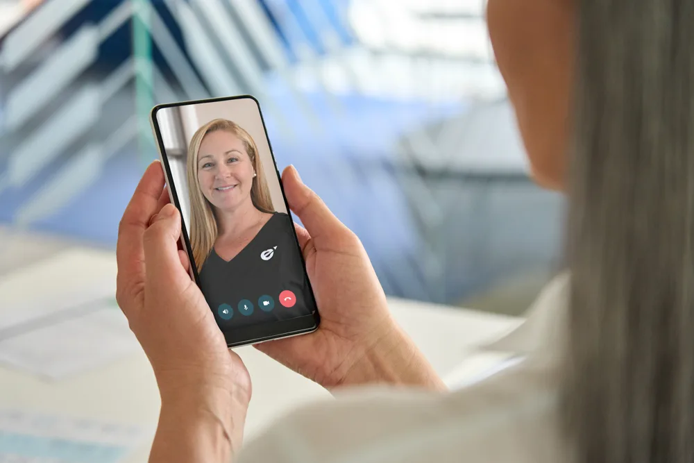 Woman attending a virtual hormone therapy visit with a Fem Excel provider on her phone